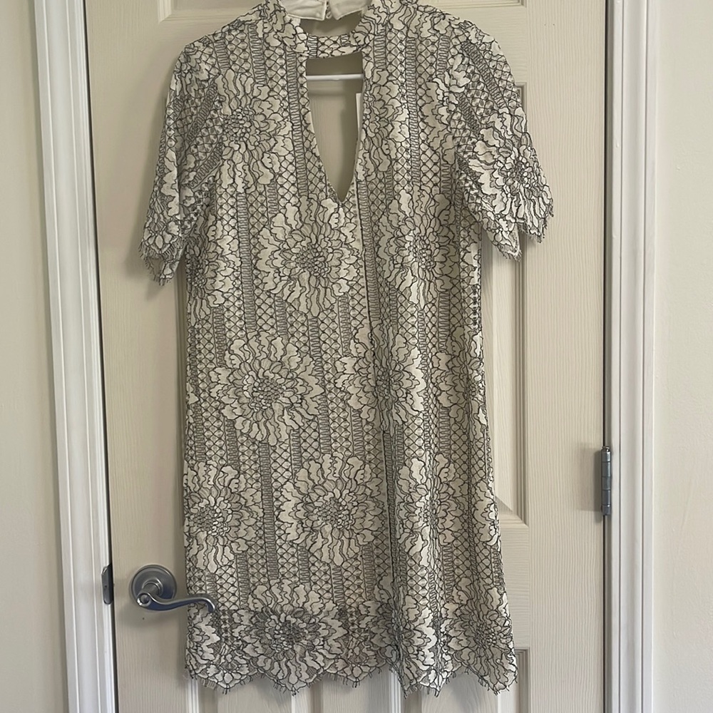 White dress with black lace/embroidery flower over top